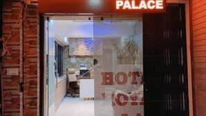 Ingången till Hotel Royal Palace med fri sikt in till receptionen och en glasdörr.