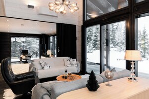A modern living room with a grey sofa, black leather chair, and a wooden coffee table.