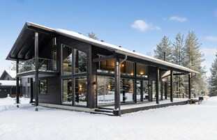 A modern, multi-story building with large windows and a covered outdoor area.