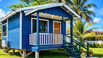 Une petite maison de plain-pied, dotée d’un porche et d’un escalier menant à l’entrée.