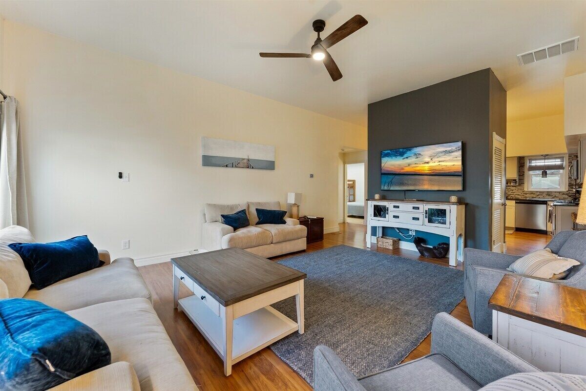 A modern living room with a sofa, coffee table, and a TV.