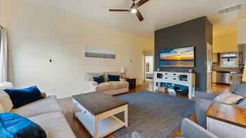 A modern living room with a sofa, coffee table, and a TV.