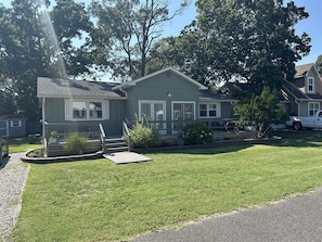 A two-story house with a front porch, a small front yard, and a driveway.