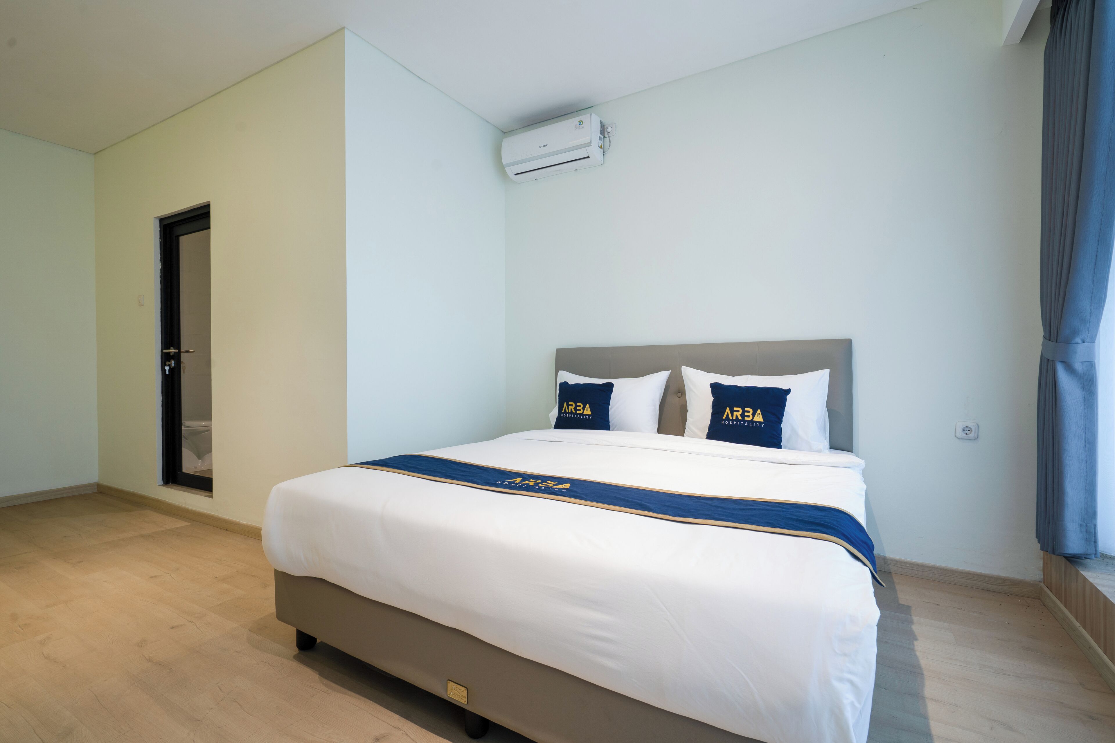 Une chambre d’hôtel avec un lit, une porte et un appareil de climatisation.