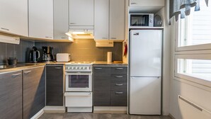 Eine moderne Küche mit dunklen Holzschränken, einem weißen Herd und einem weißen Kühlschrank.
