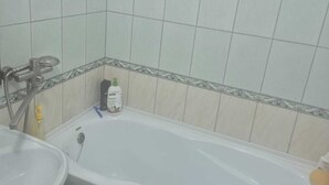 A bathroom with a bathtub, a sink, and a toilet. - apartament confort in chisinau (Chișinău)