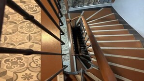 A spiral staircase with a metal handrail and a patterned floor. - PARIS ROOMS & DREAMS HOTEL (Paris)