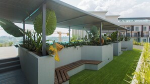 Un jardin sur le toit, agrémenté de jardinières, d’un banc en bois et offrant une vue sur la ville.
