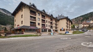 Een hotel met meerdere verdiepingen, voorzien van balkons, een restaurant en een parkeerplaats.