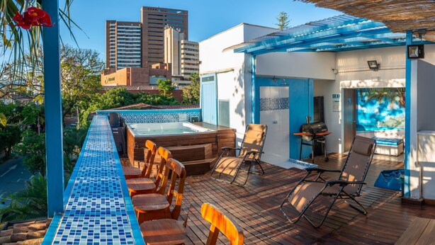 Una terraza en la azotea con piscina, zona de estar y bañera de hidromasaje.