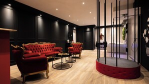Ein luxuriöses Zimmer mit rotem Sofa, einem runden roten Tisch und einer Schwarz-Weiß-Farbgestaltung.