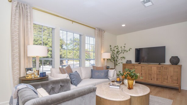 A living room with a grey sofa, two side tables with lamps, a TV, and a wooden cabinet. - New! Shug's Station, 2 BR, 2BA condo close to Auburn University, sleeps 4! (Auburn)