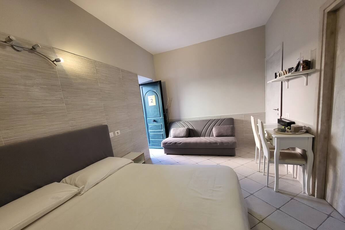 Une chambre d’hôtel comprenant un lit, un canapé, un bureau avec une chaise et une armoire.