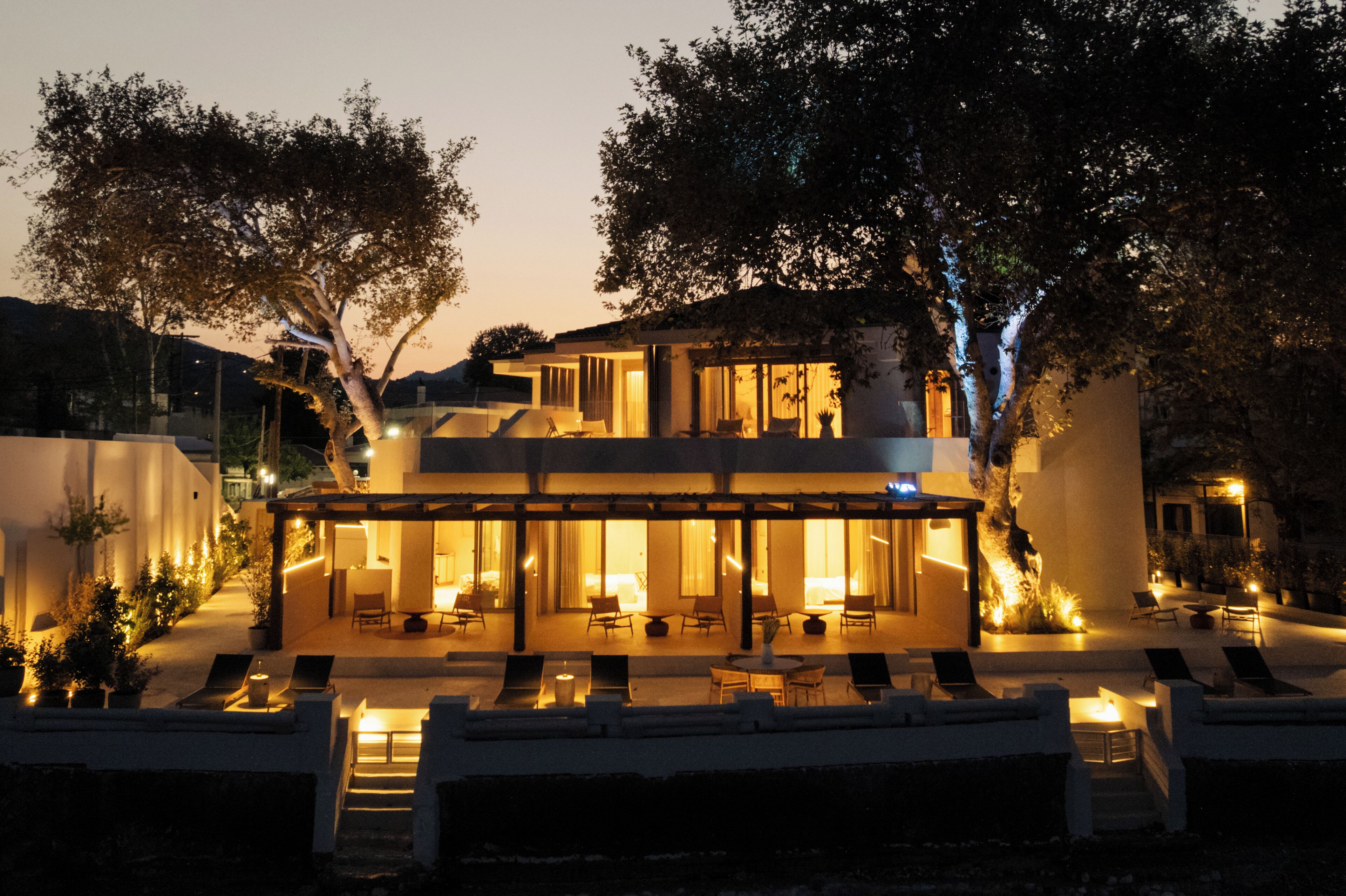 A modern house with a covered patio, outdoor seating, and a pool.