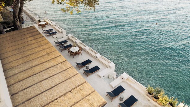 A rooftop terrace with outdoor seating and a view of the sea. - Beau Rivage Suites (Aigialeia)