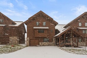 Un bâtiment recouvert de neige, doté d’une entrée centrale et d’un escalier menant à la porte principale.