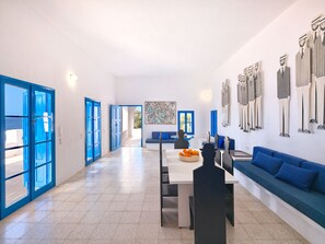 A modern interior with a dining area, a sofa, and a wall with decorative items.