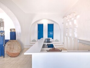 A modern kitchen with white countertops, a central island, and blue doors in the background. - Artistic Villa Hideaway (Ios)