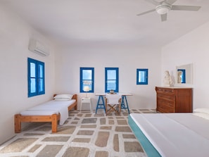 A room with two beds, a desk, and a dresser.