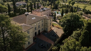 A large, historic building with multiple floors and a courtyard. - Hotel with swimming pool in Riparbella (Riparbella)