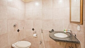A modern bathroom with a toilet, sink, and shower. - Swiss Traffalgaar Luxury Hotels (Nashik)