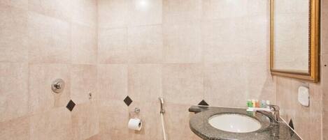 Un baño moderno con inodoro, lavamanos y ducha.
