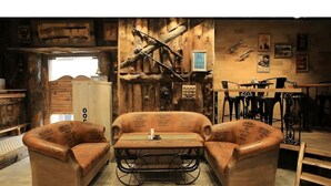 A rustic room with a wooden wall, a sofa, a coffee table, and a dining table. - Swiss Traffalgaar Luxury Hotels (Nashik)