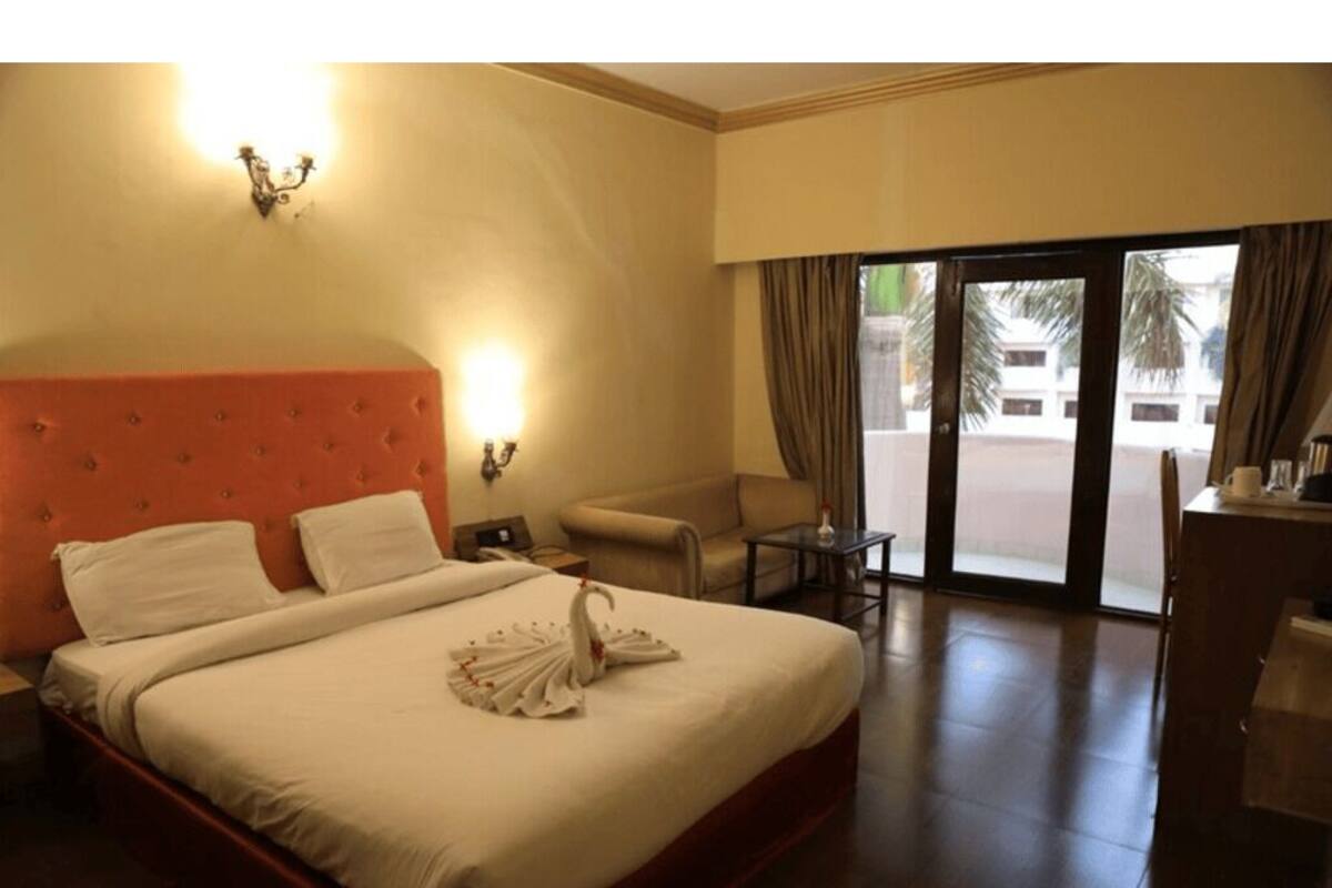 Una camera d'albergo con un letto grande, una scrivania, una sedia e vista all'esterno.