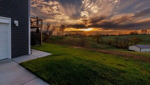 A residential property with a grassy yard, a wooden deck, and a garage.