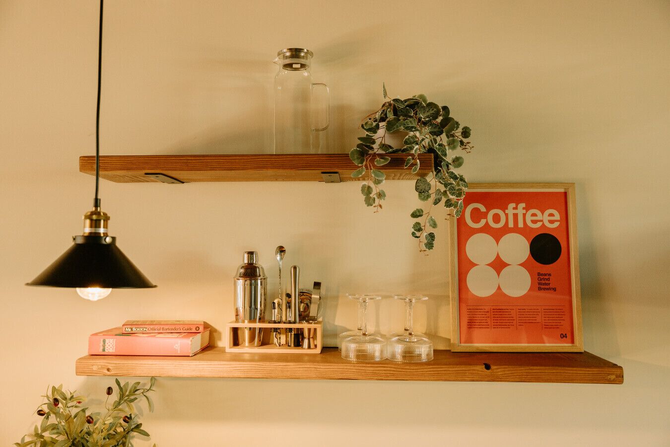 A coffee-themed shelf with a coffee poster, a hanging plant, and various coffee-making items.