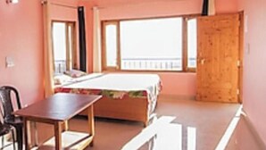 Una camera da letto con un letto, una porta in legno e una finestra.