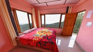 Una camera da letto con un letto, ampie finestre e una porta finestra.