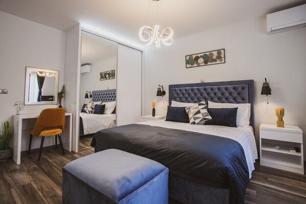 A modern bedroom with a large bed, a desk, and a chair.