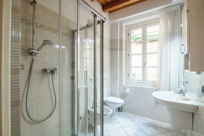A modern bathroom with a glass-enclosed shower, a toilet, and a sink. - Centro Storico (Como)
