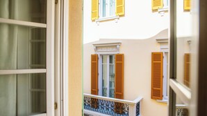 A balcony with a white balustrade and a window with wooden shutters. - Centro Storico (Como)