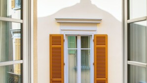 A doorway leading to a room with a window and a metal fence. - Centro Storico (Como)