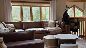 Ein gemütliches Wohnzimmer mit einem braunen Ledersofa, zwei runden Couchtischen und einem Kamin.