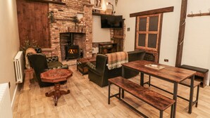 Un salón acogedor con chimenea de ladrillo, muebles de madera y un televisor.