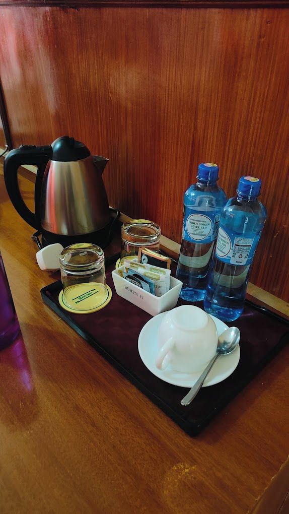 A tray with a kettle, water bottles, a cup, and a tea set.