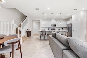 A modern kitchen with white cabinets, a built-in microwave, and a stainless steel refrigerator. - 5BR house at Windsor Cay resort, sleeps 14 (Clermont)