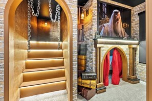 Ein Zimmer mit einer Holztreppe, einem Kamin mit Steinwand und einem großen, gerahmten Bild an der Wand.