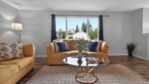 Un salon avec un canapé, une table basse et une lampe.
