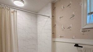 Un baño con ducha, inodoro y lavamanos.