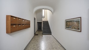 Ein Flur mit Schließfächern links, einer Treppe in der Mitte und einem gerahmten Bild rechts.