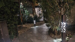 A paved pathway with decorative lighting fixtures and lush greenery. - etna hill (Catania)