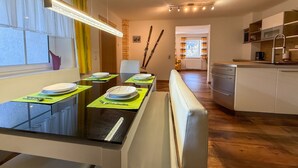 Cocina moderna con comedor, equipada con estufa, fregadero y ventana con cortinas.
