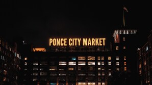 Un edificio con letreros iluminados que dicen 'Ponce City Market' de noche.