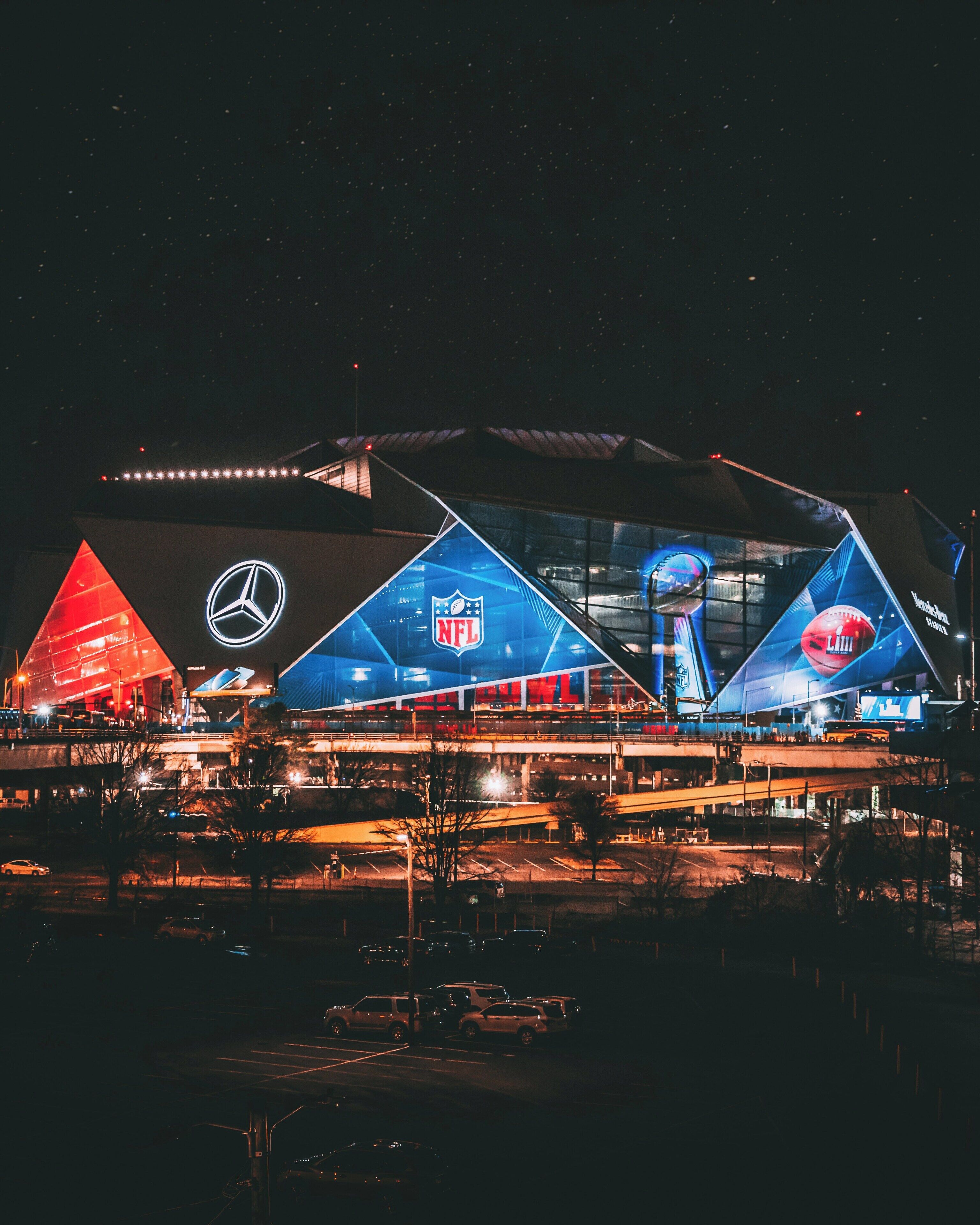 A large, modern stadium with prominent branding and illuminated signage.