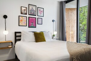 Una camera da letto moderna con un letto, comodini e una finestra che si affaccia sul verde.