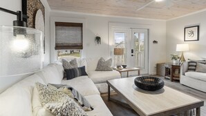 Un soggiorno moderno con un divano bianco, un tavolino in legno e una ventola a soffitto.